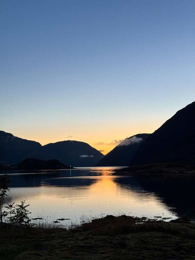 Stille skumring over Sognefjorden, med det siste lyset speilet i vannet